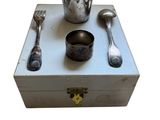 une boîte en argent sur laquelle sont représentées des cuillères, des cuillères et une tasse