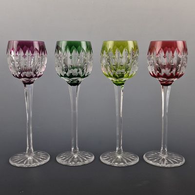 four wine glasses are lined up in a row on a table