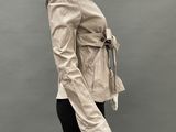 an image of a mannequin wearing a beige jacket and black pants