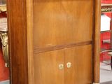 a wooden cabinet with a clock on top of it in a room