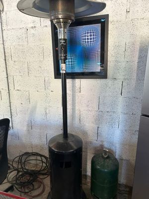 a gas heater sitting on top of a table next to a refrigerator