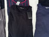 three pairs of men ' s t - shirts on display in a store