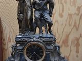 une statue en bronze représentant un homme et une femme sur une horloge
