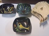 four bowls on the table with a bird on them