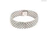 gros plan d'un bracelet en argent sur fond blanc