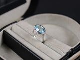 une bague dans un écrin, sertie d'une topaze bleue