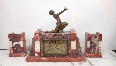 a statue of a woman holding a ball on top of a clock