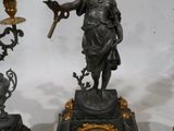 trois horloges différentes et une statue posée sur une table