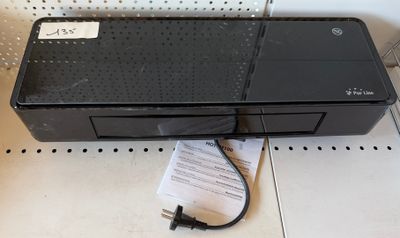 une photo d'une imprimante noire posée sur un comptoir