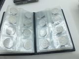 a lot of silver coins in a case on a table