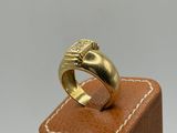 a close up of a gold ring on a wooden stand