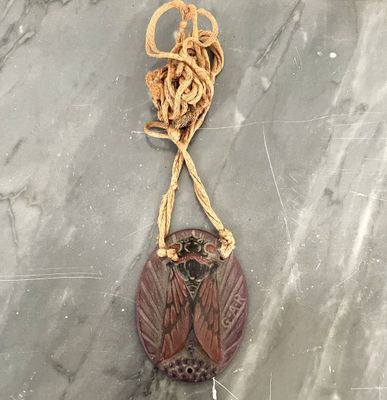 une photo d'un collier orné d'un oiseau