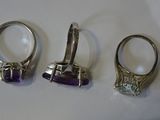 three silver rings with amethorate stones on them on a white surface