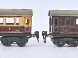 two toy trains sitting side by side on a white surface
