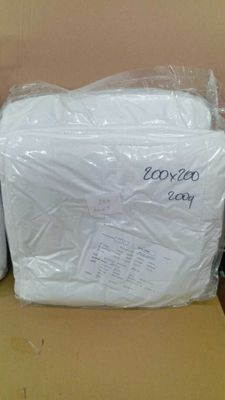 deux rouleaux de papier toilette emballés dans du plastique, posés sur une boîte en carton