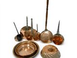 a lot of copper colored pots and pans on the table
