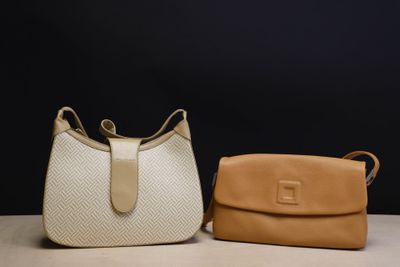 two purses sitting on top of a table next to each other