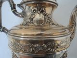 a silver tea pot that is sitting on a table