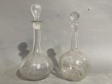 two glass bottles sitting next to each other on a table