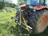 a tractor that is parked in the grass by a fence