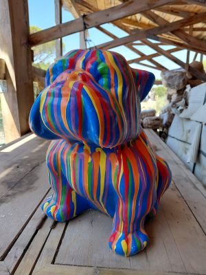 une statue colorée représentant un chien assis sur une table en bois