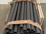 a stack of black pipes sitting on a pallet in a warehouse