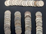 some silver coins are arranged in a row on a black surface