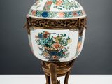 an ornately decorated vase with a bird on top of it