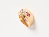 an image of a gold ring with pink and white stones on a white surface