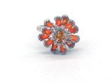 une image représentant une bague sertie de pierres orange sur un fond blanc