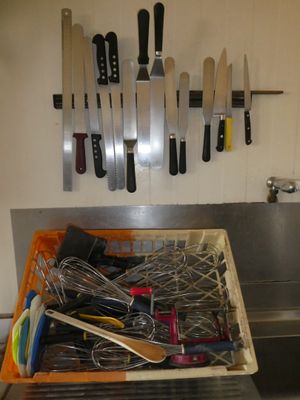 de nombreux couteaux accrochés au mur au-dessus de l'évier de la cuisine