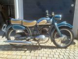 a blue motorcycle parked in front of a garage