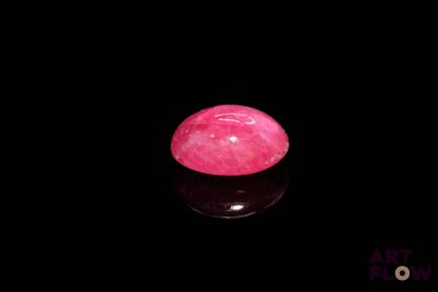 un gros plan d'une pierre rose posée sur une surface noire