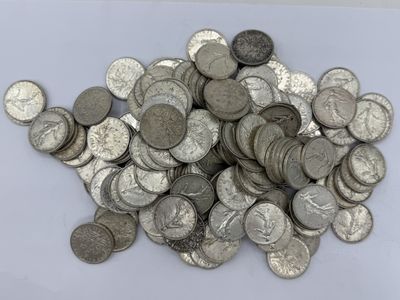 un tas de pièces d'argent posé sur une surface blanche
