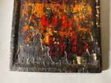 painting of a group of people on a wooden board on a table
