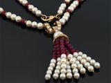 une image représentant un collier orné de perles et de grenats sur un fond noir