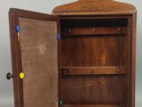une petite armoire en bois dont la porte est ouverte, laissant apparaître une surface grise