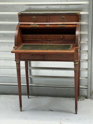 un bureau ancien avec un plateau en marbre et des ferrures en laiton