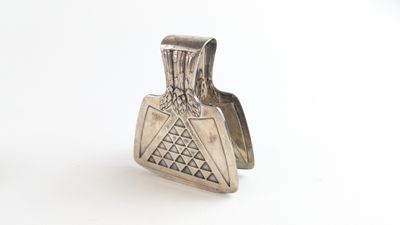 un gros plan d'un objet argenté posé sur une surface blanche