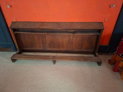 un banc en bois devant un mur orange