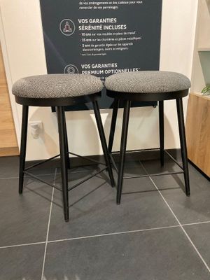 deux tabourets placés l'un à côté de l'autre sur un sol carrelé