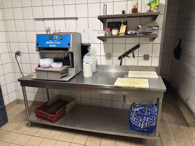 a kitchen with a stainless steel table and a blue machine