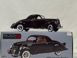 an old model of a black car sitting on top of a box