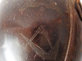 a brown vase with a design on it sitting on a table
