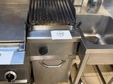several stainless steel appliances are lined up on a tiled floor