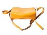 yellow leather handbag on a white background with a strap