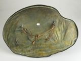 a sculpture of a bird on a leaf shaped plate