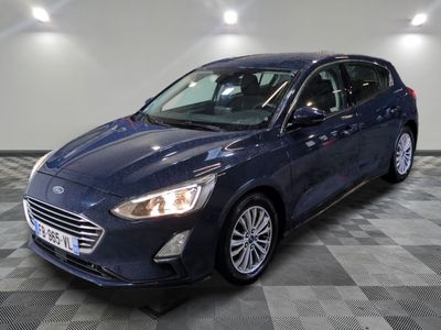 une Ford Focus bleue garée sur un sol à damier dans un garage
