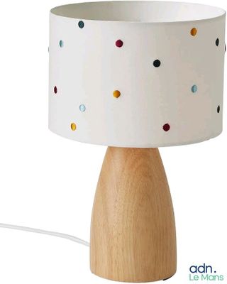 une photo d'une lampe de table avec un pied en bois orné de pois colorés