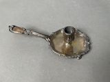an antique silver plate with a candle holder on top of it